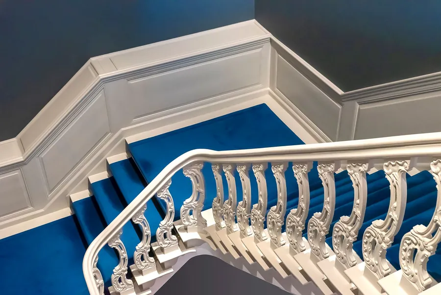 Ornate period staircase with a carpet runner, the kind of access route every slab and bag is carried up on an Exeter bathroom project