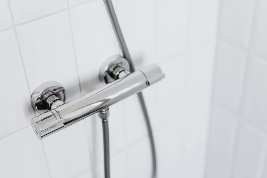 Chrome thermostatic shower valve on white tiling in an Exeter bathroom renovation