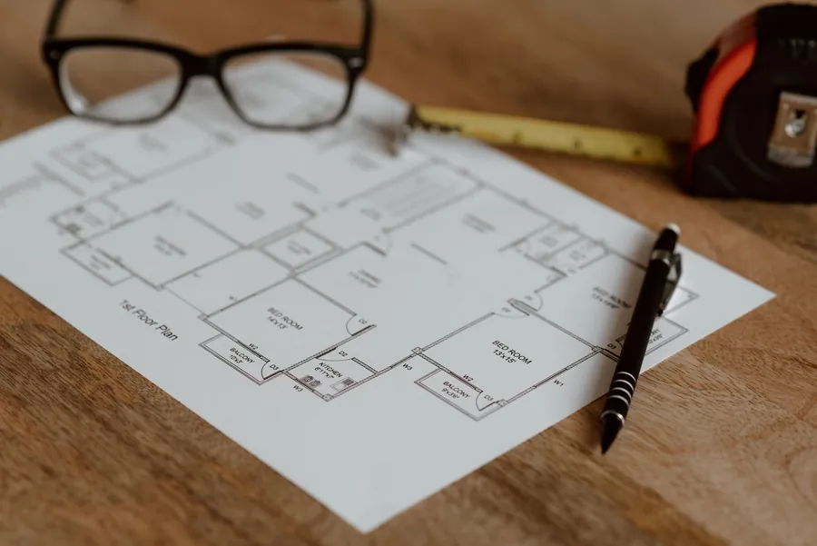 A scale floor plan with a pen, ruler and tape measure, the stage where an Exeter bathroom layout is tested before ordering