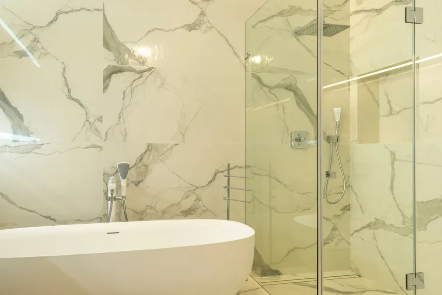 Marble Exeter bathroom with the shower enclosure separated from the freestanding bath, the wet and dry zones a layout is built around