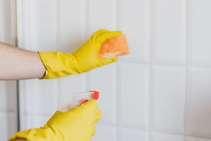 Cleaning bathroom surfaces with a spray and sponge, the everyday products that etch calcareous stone in hard water areas