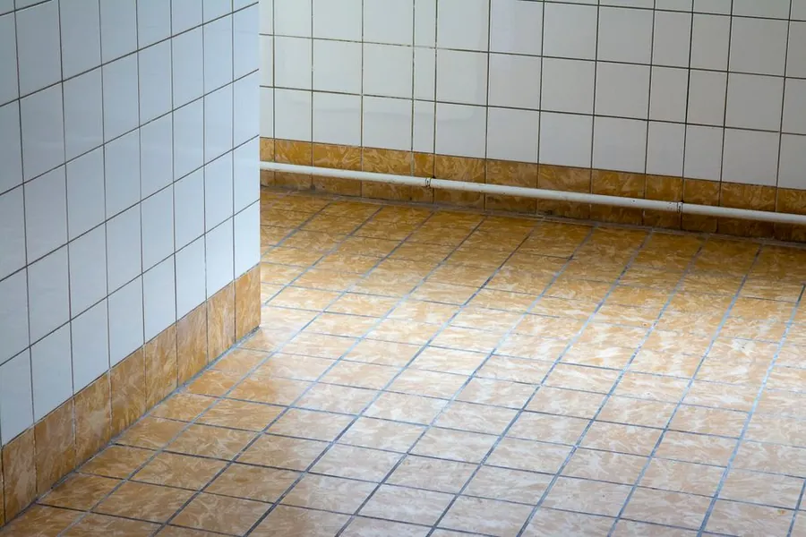 A clean tiled floor running unbroken beneath a wall-hung WC in an Exeter bathroom