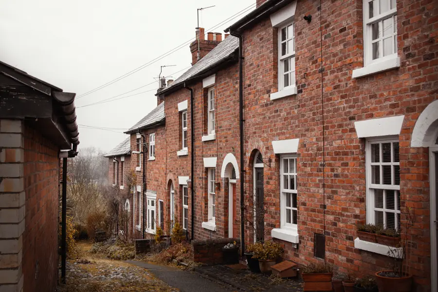 A row of traditional brick terraced houses of the kind found across Exeter, where WC positions follow the original soil stack