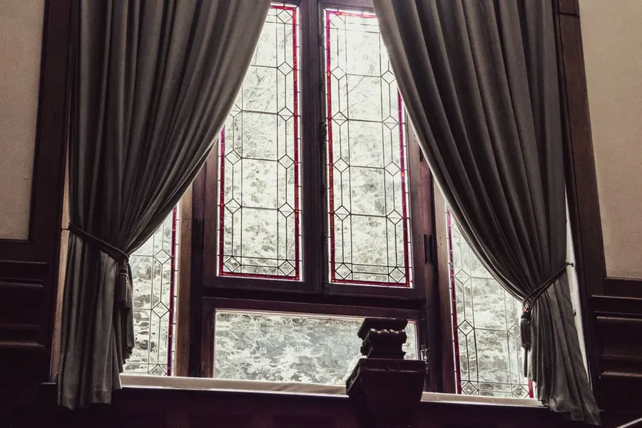 A leaded period window in a historic interior, the kind of glazing that rules out cutting in a bathroom vent
