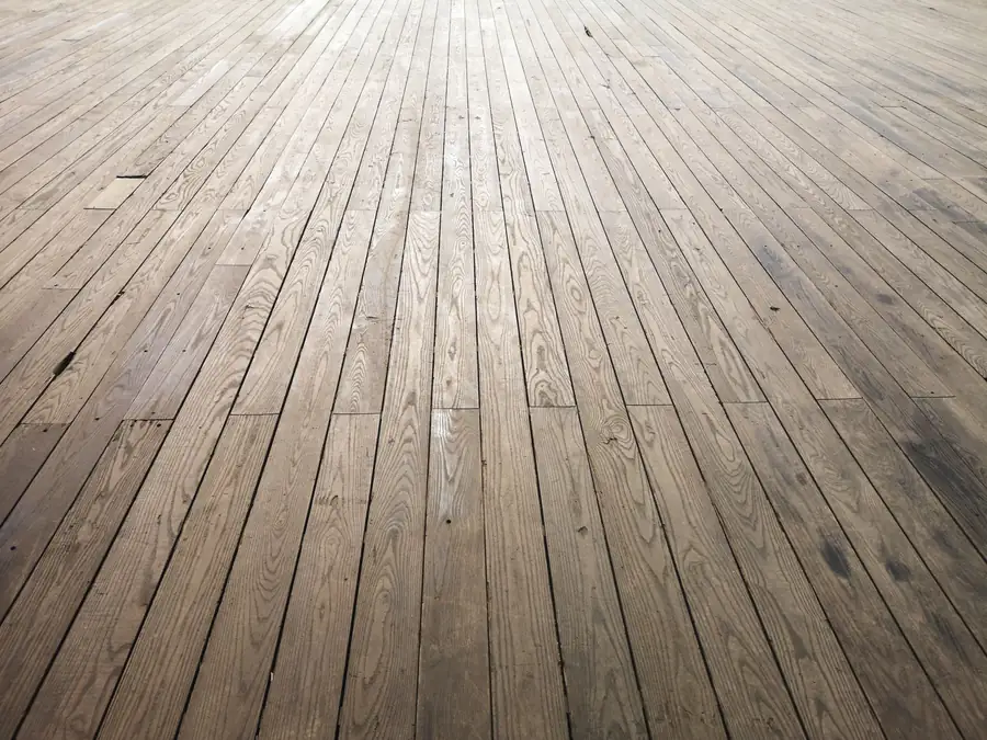 Aged timber floorboards running away from the camera, the kind of period first floor an Exeter stone bathroom has to be built on