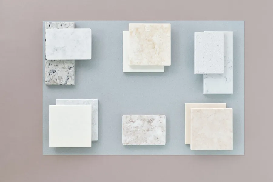 Stone-effect porcelain and marble tile samples laid out for comparison during an Exeter bathroom specification