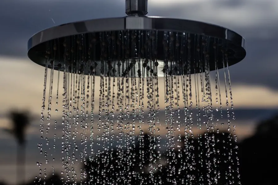 Water flowing from a shower head, the flow rate question behind every spa shower in Exeter