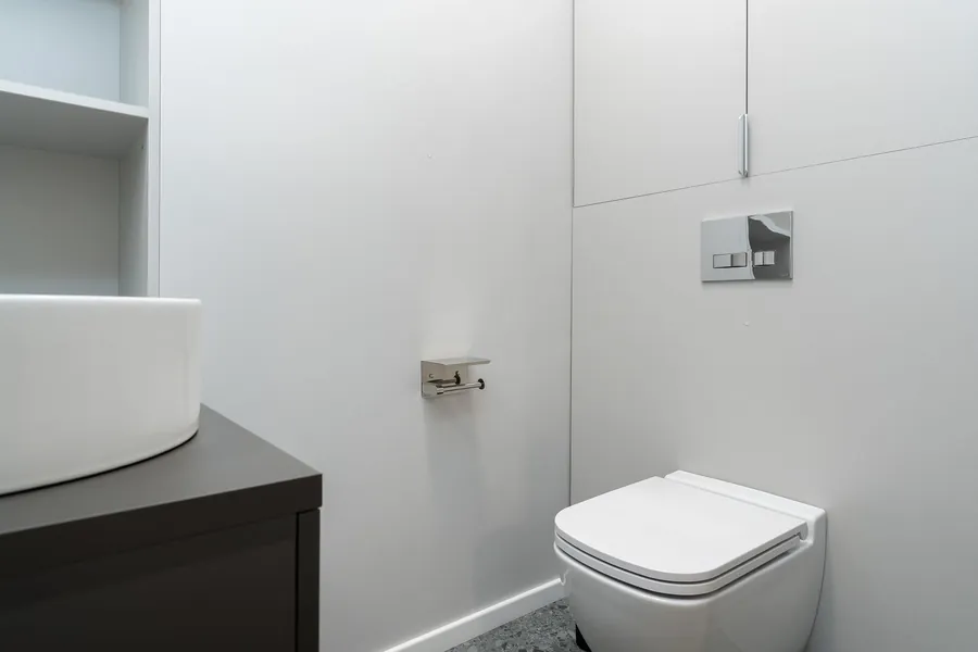 Wall-hung WC with concealed cistern and chrome flush plate, the fixture whose position is set by the soil stack in an Exeter bathroom