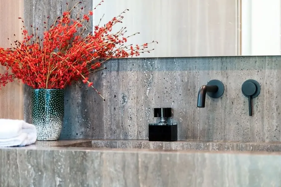 Black brassware against stone in an Exeter bathroom, one of the finishes homeowners ask about most