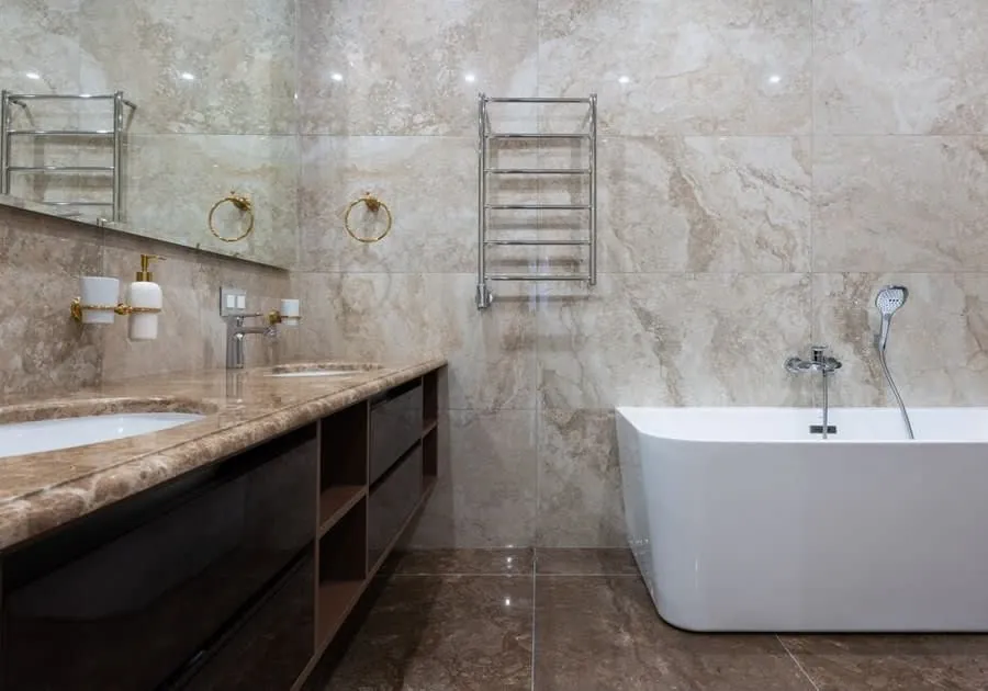 A marble bathroom in Exeter with the vanity on one wall and the bath on the other, the arrangement most layouts are working towards
