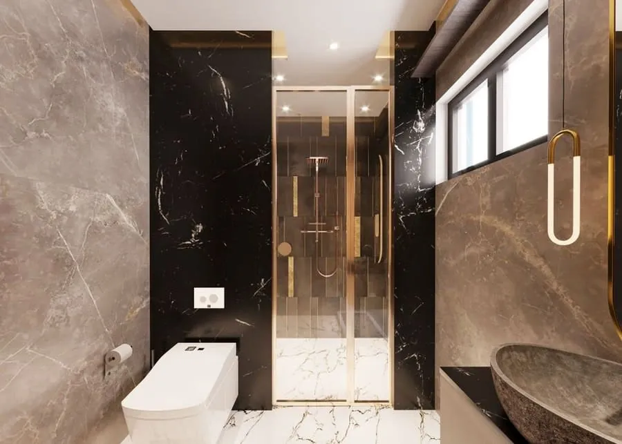 Boutique hotel bathroom design in dark marble with brass shower fittings