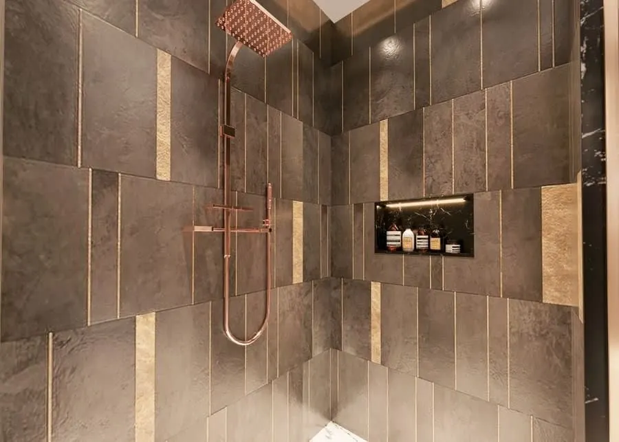 Brushed brass shower valve and riser against natural stone tiling in an Exeter bathroom