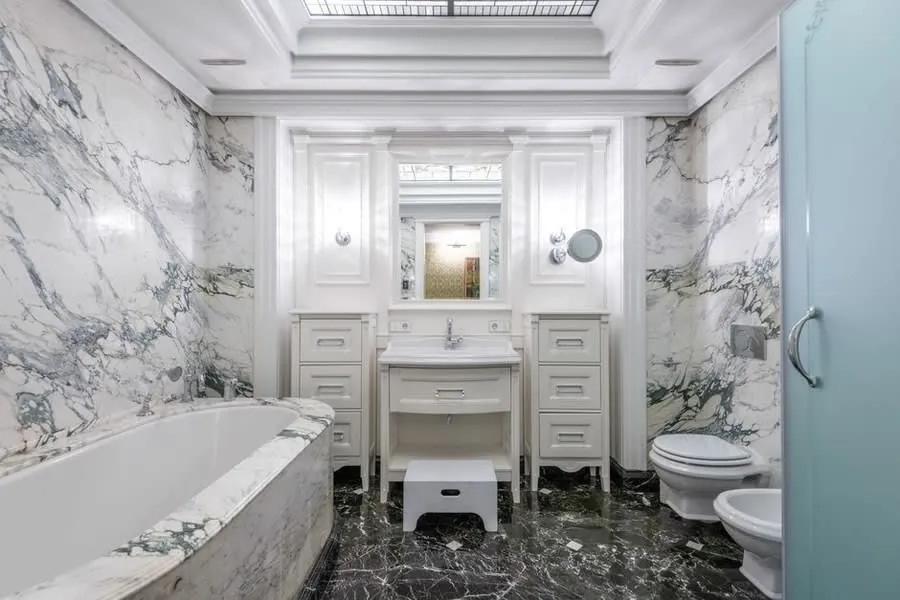 Marble-lined luxury bathroom in Exeter with twin classic vanity units