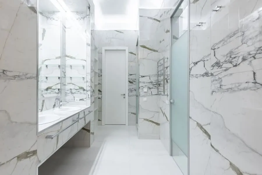 A marble-tiled walkthrough shower in an Exeter bathroom, the finish level the panels-or-tiles question is really about