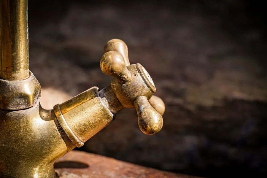An aged brass tap that has patinated, showing how an unlacquered living finish changes over time