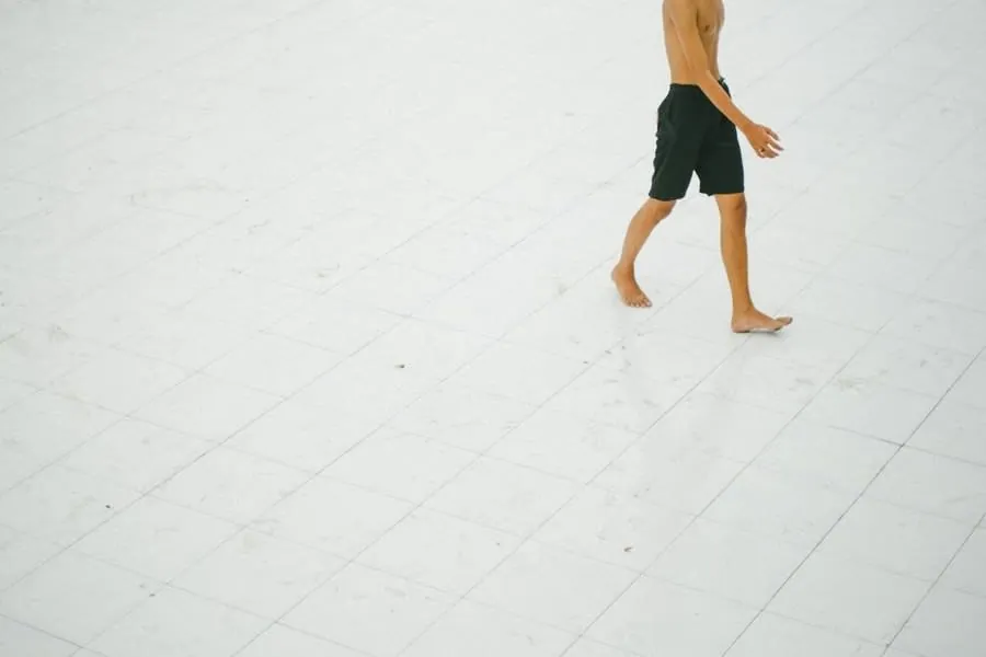 Person walking barefoot across a pale tiled floor, the condition bathroom floors are rated for