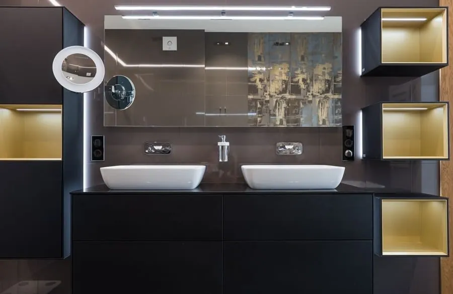 Concealed LED strip lighting washing across a dark bathroom vanity