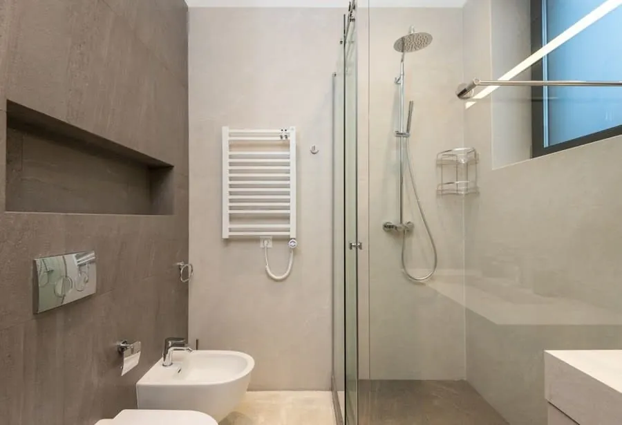 Grey tiled shower with a curved rail and level-access enclosure