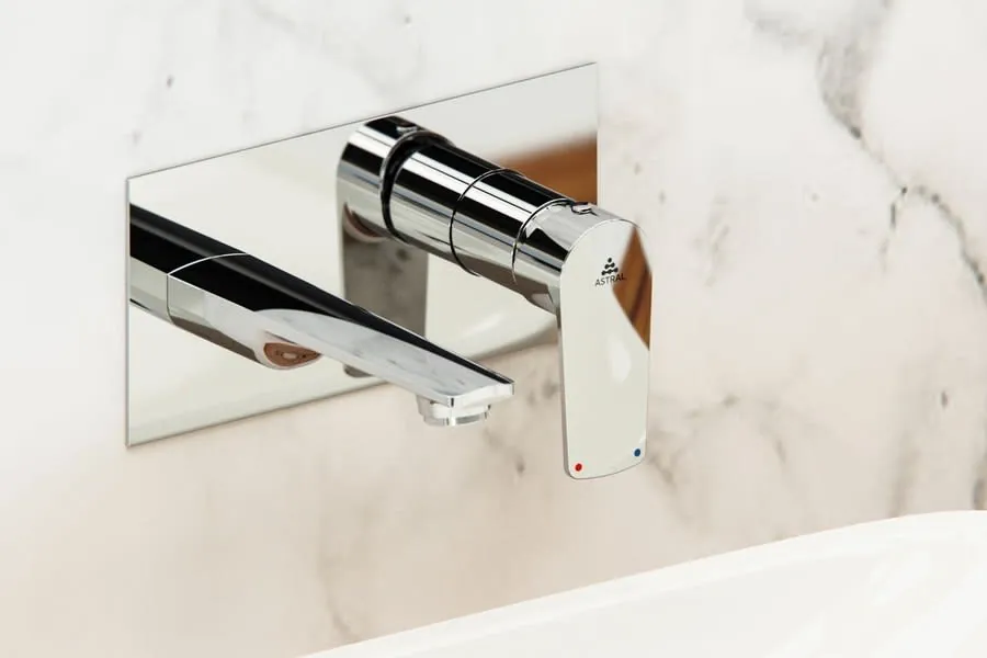 A chrome wall-mounted basin mixer against marble in an Exeter bathroom