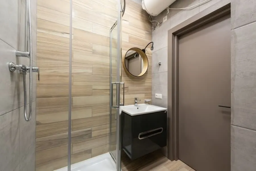 A compact en-suite shower room with wood-effect tiling