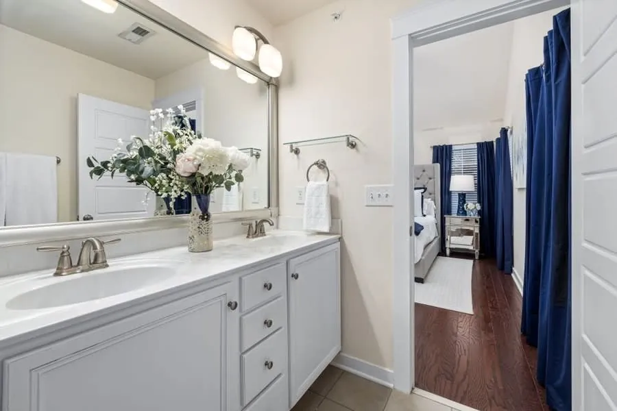 A bathroom vanity beside an open door leading through to a bedroom