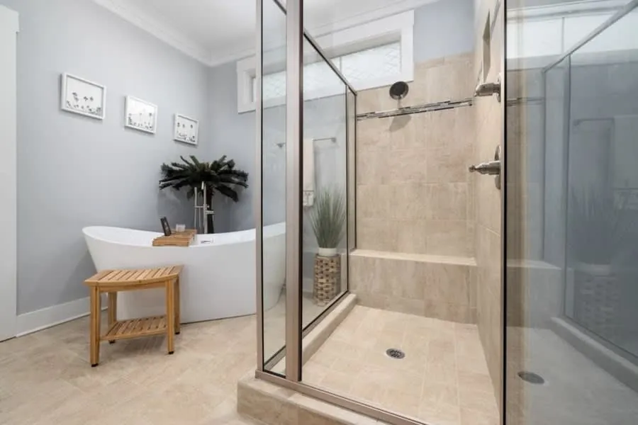 Bathroom pairing a freestanding bath with a walk-in shower and a timber bench