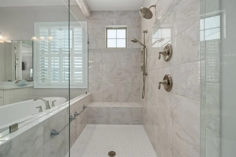 Spacious level-access marble shower with no tray lip, easy to step into