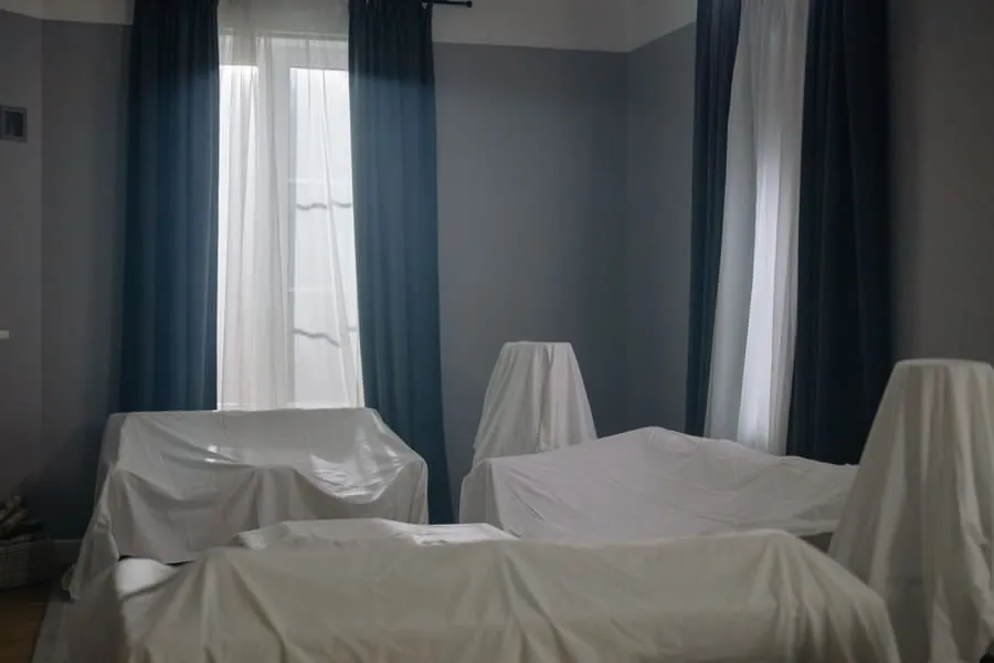 Furniture protected under dust sheets in a room adjoining building work