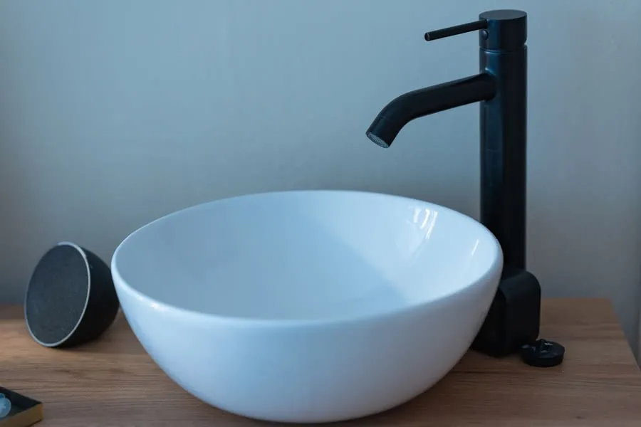 A matt black tap on a white counter-top basin, the finish that shows limescale most clearly