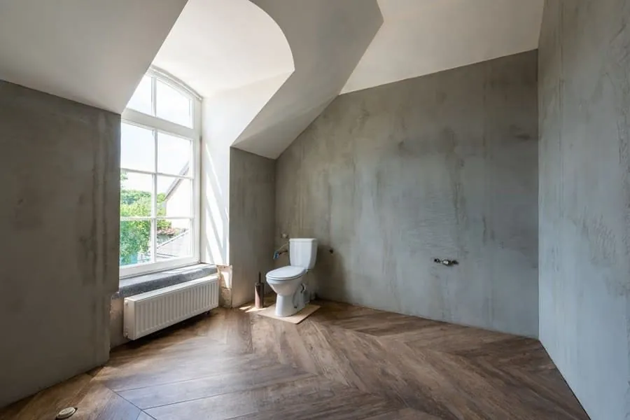 A microcement wall finish above a wood-effect floor in a bathroom