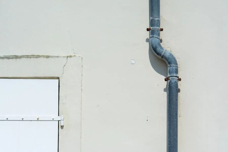 A drainpipe on the outside wall of a house, the gravity connection every relocated WC has to reach