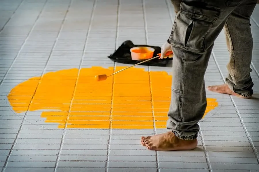 Liquid waterproofing membrane being applied over a tiled floor before finishing