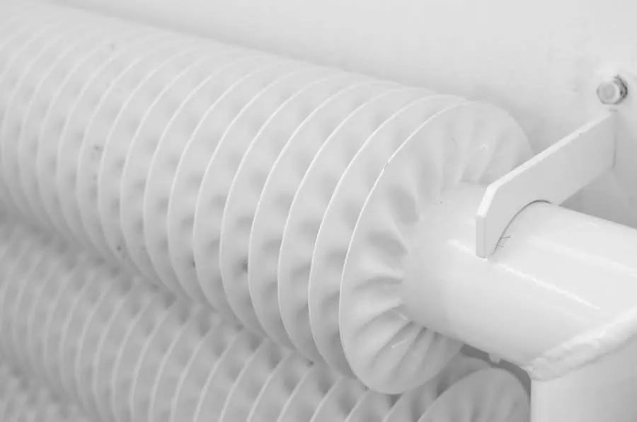 Close detail of a white panel radiator of the type underfloor heating replaces
