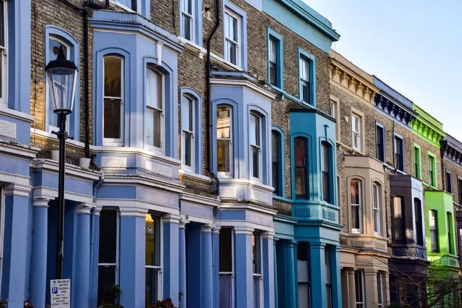 A terrace of bay-fronted Victorian houses painted in pale colours