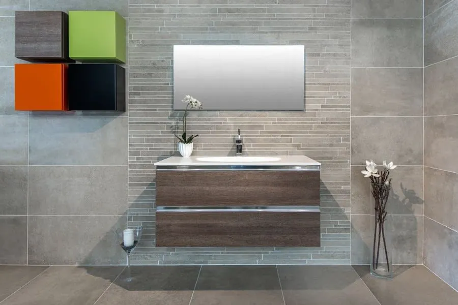 A wall-hung walnut vanity unit floating above the floor against stone-effect tiles