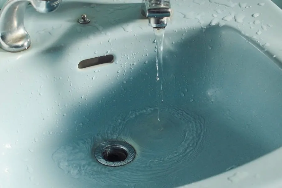 Water running from a bathroom tap, the thing that decides how long a finish lasts in Devon