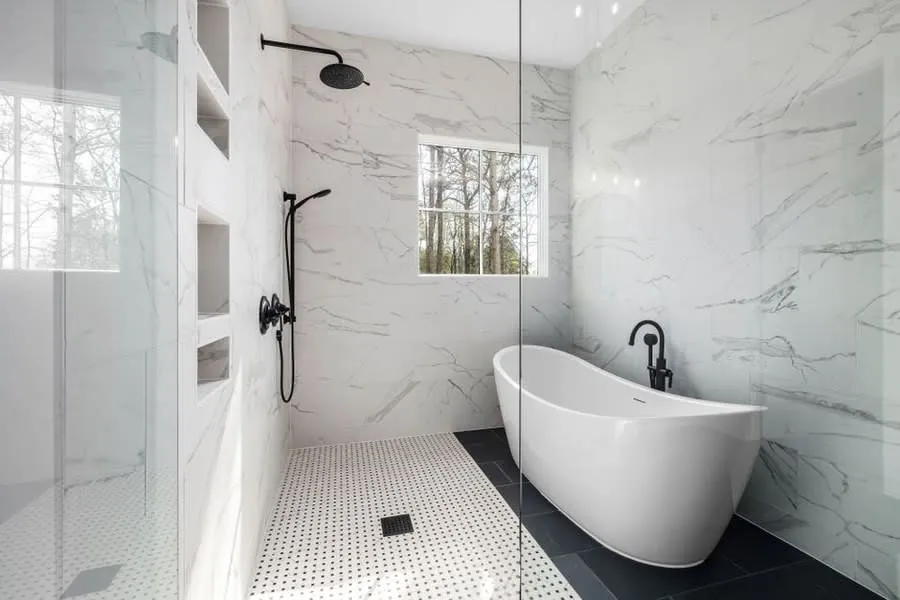 Marble wet area with a level floor, freestanding bath and frameless screen