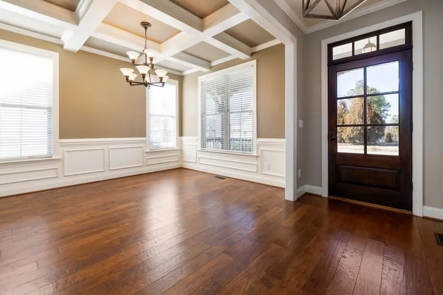 A solid wood floor in a bright panelled room