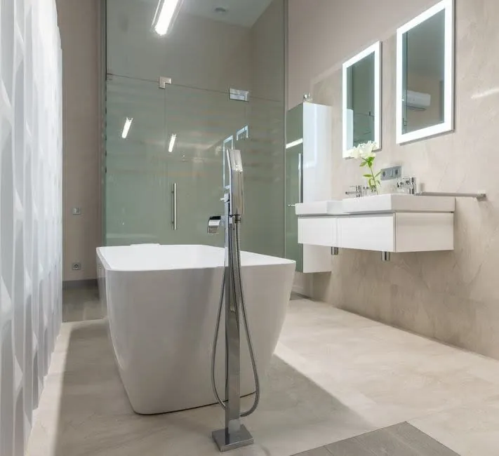 Minimal bathroom with a freestanding bath and wall-hung basin unit in an Exeter home