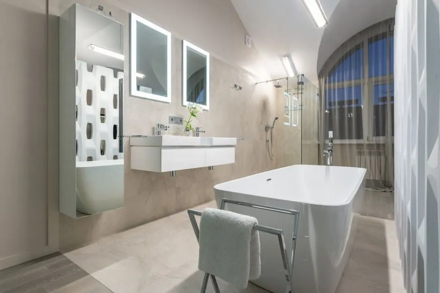 Freestanding bath beneath an arched window in a luxury Exeter bathroom