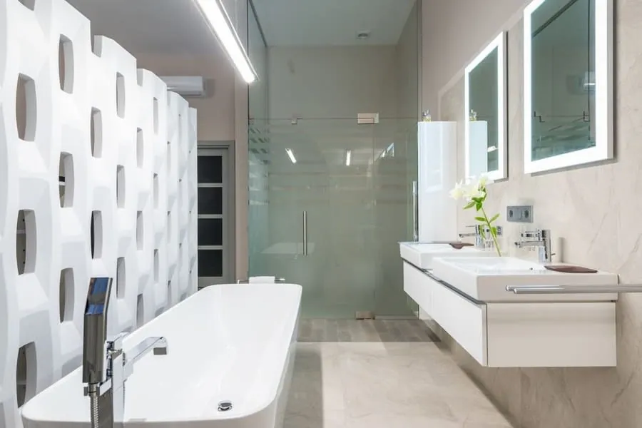 Freestanding bath in an Exeter bathroom alongside a wall-hung double vanity