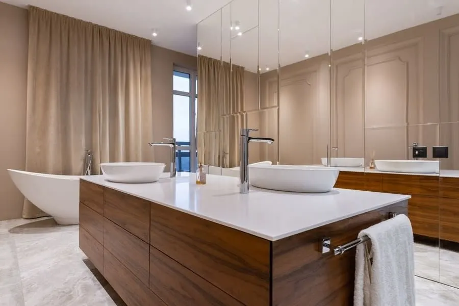 Bathroom design in Exeter featuring a walnut island vanity with twin counter-top basins