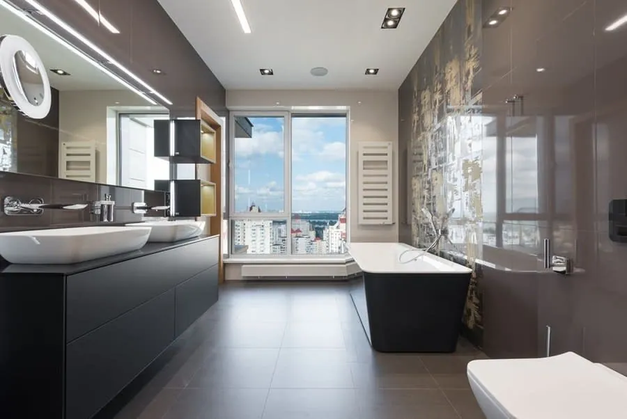 Marble bathroom with a freestanding bath beside floor-to-ceiling glazing in an Exeter property