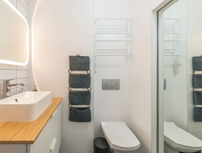 Compact bathroom with an oak shelf basin, glass shower screen and towel rail