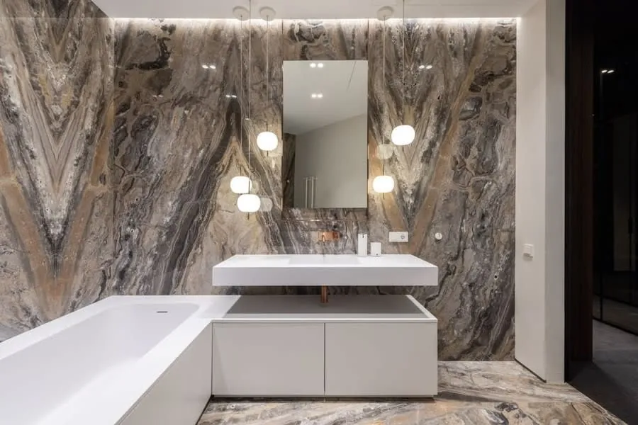 Luxury bathroom fitted in Exeter with a full-height marble feature wall behind the basin