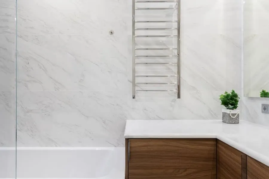Marble bathroom with a walnut vanity unit and heated towel rail