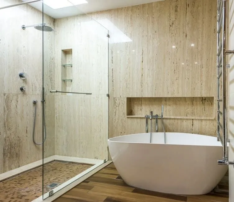 Wet room installation in Exeter with travertine walls, a freestanding bath and level-access shower