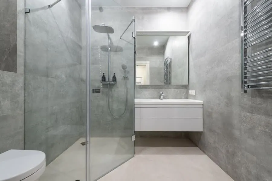 Wet room in Exeter tiled in large-format grey stone with a level-access shower area